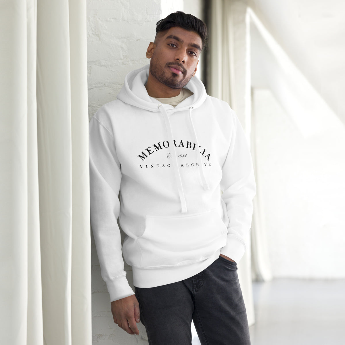 Hombre apoyada en columna vistiendo sudadera color blanco con estampado Memorabilia Vintage Archive.