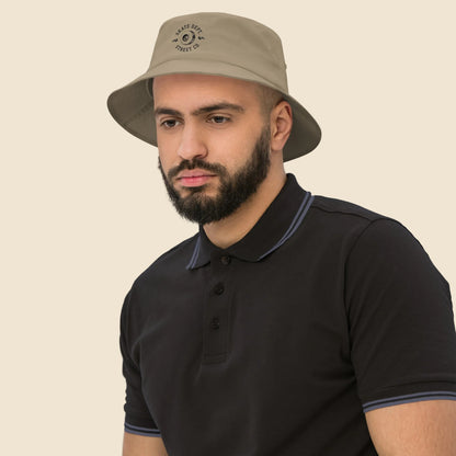 Hombre vistiendo gorro de pescador caqui de estética streetwear con ilustración retro de skate.