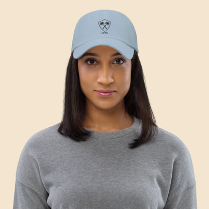 Mujer vistiendo gorra dad hat azul claro de estética coastal vintage con bordado frontal de palmeras.