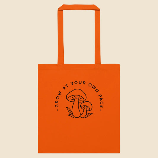 Bolsa de tela clásica en color naranja con ilustración botánica silvestre de estilo line art.