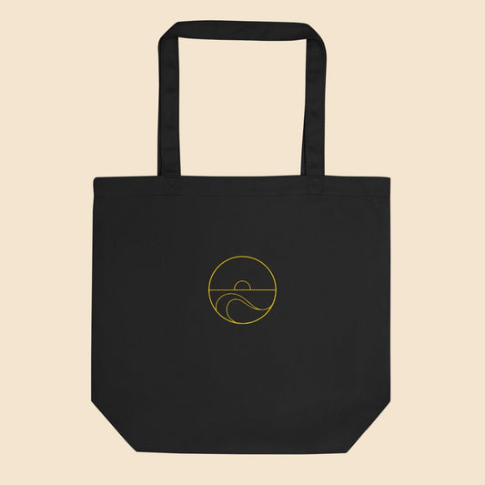 Ecobolsa de algodón orgánico color negro con estampado circular dorado de sol y olas del mar.