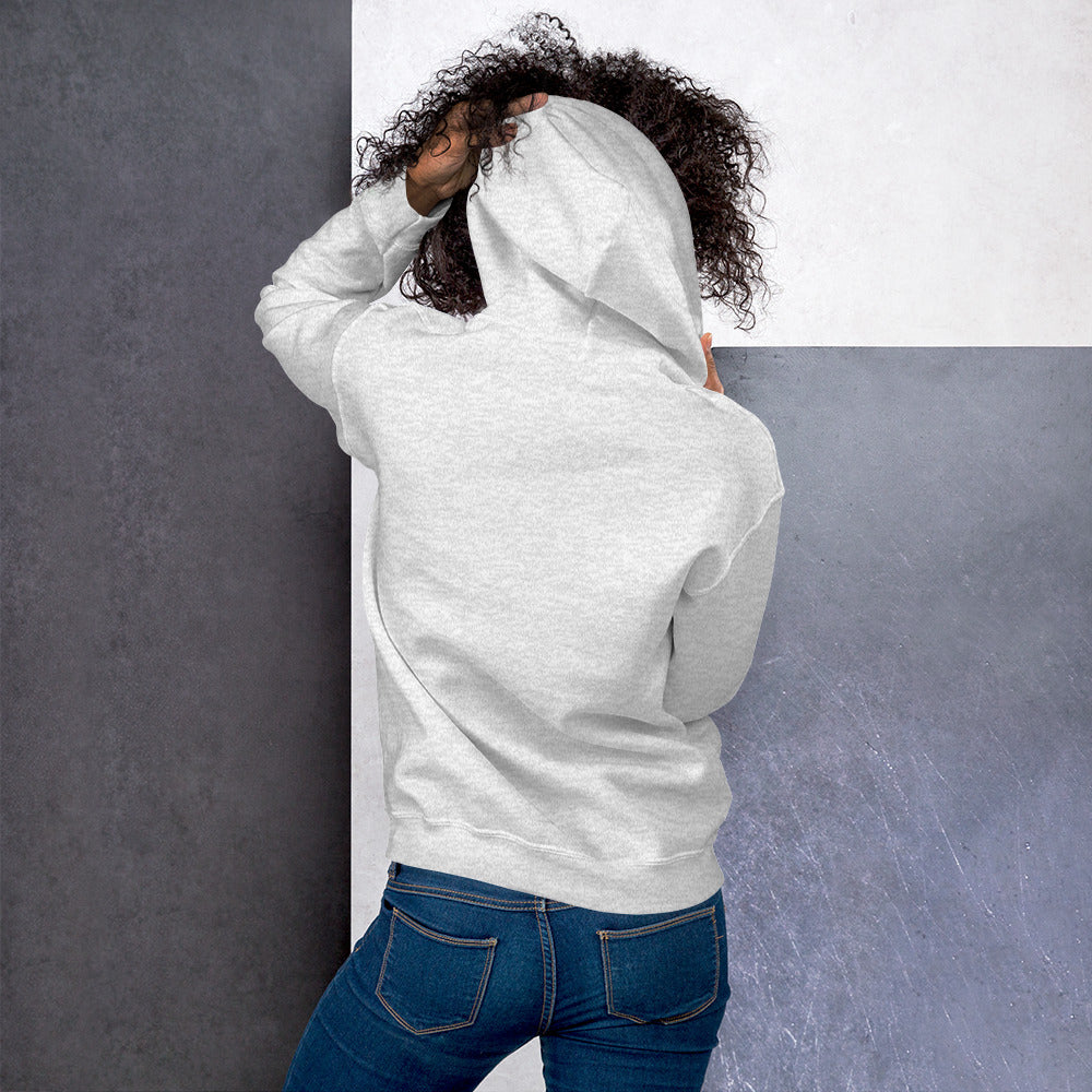 Modelo femenino de espaldas ajustando la capucha de su sudadera deportiva.