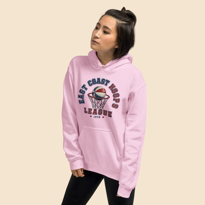 Mujer vistiendo sudadera con capucha rosa pastel con estampado deportivo vintage.