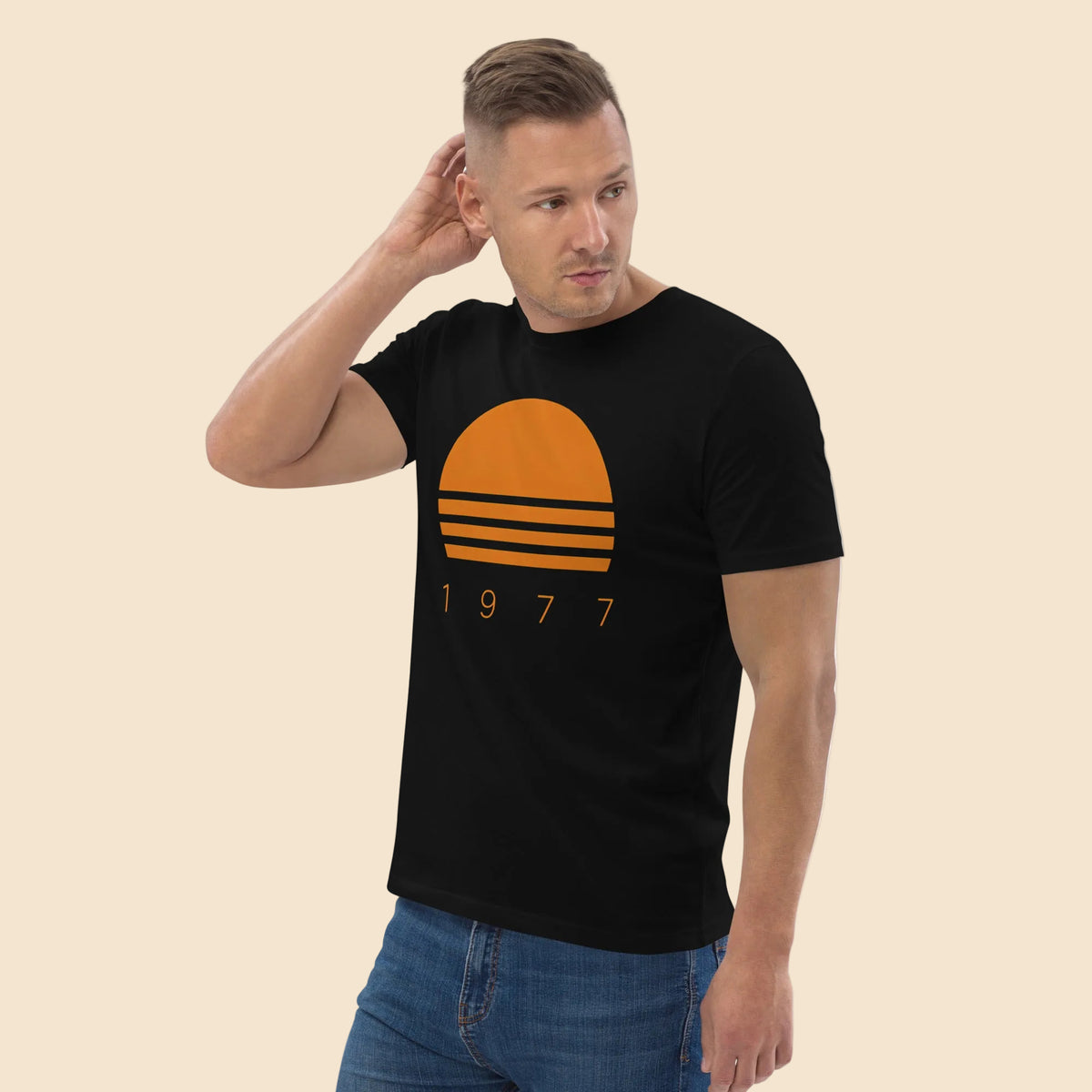 Hombre vistiendo camiseta negra unisex con gráfico de sol a rayas estilo años 70
