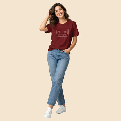Chica vistiendo camiseta burdeos con gráfico minimalista de casete de audio
