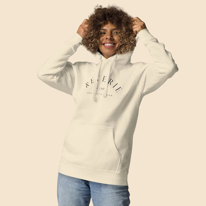 Mujer ajustando la capucha de su sudadera color hueso con estampado Nostalgic Mood.