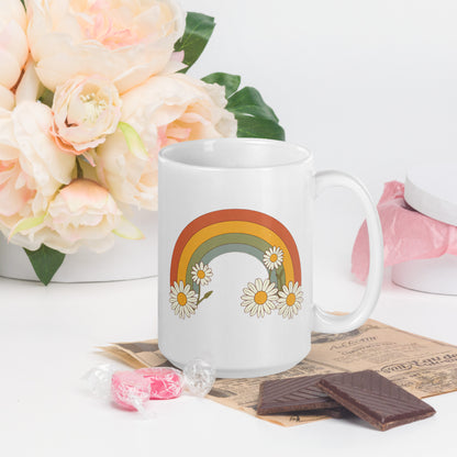 Taza de cerámica blanca con diseño floral de arcoíris retro junto a flores