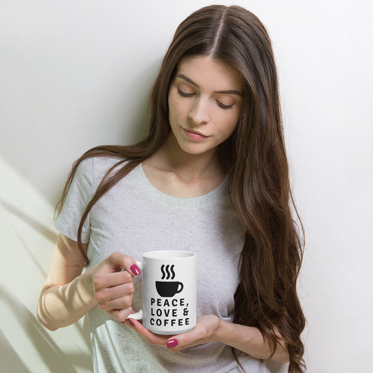 Persona sosteniendo una taza blanca de cerámica con diseño Peace Love Coffee de estilo vintage y minimalista.